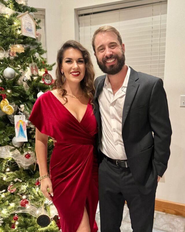 A couple standing beside a Christmas tree
